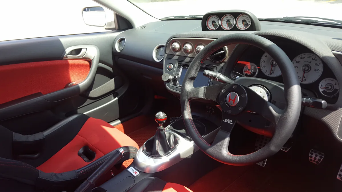 Interior view of sports car cockpit featuring textured bucket seats and clean center console layout