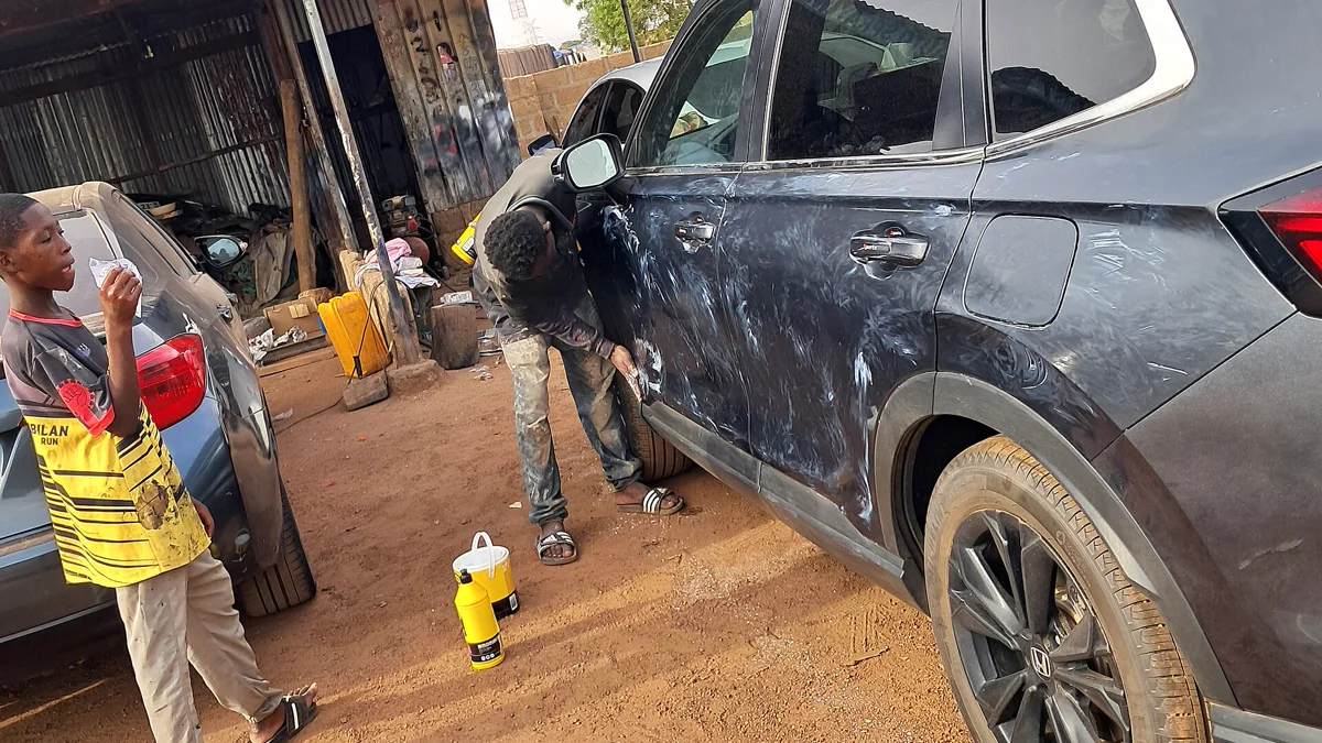 Dual-action automotive paint machine polisher on body panel Technician polishing vehicle clear coat to remove decal ghosting shadows